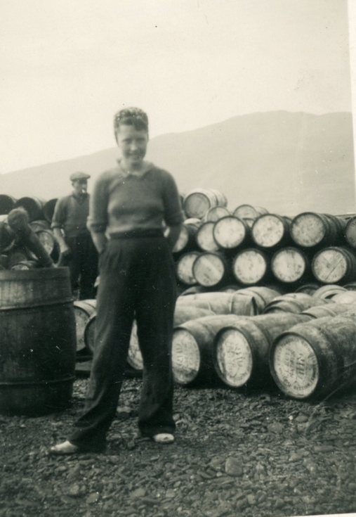 Bella Mackay standing beside a barrel stack