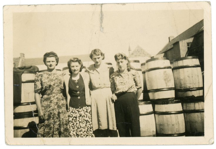 Group standing beside a barrel storage area