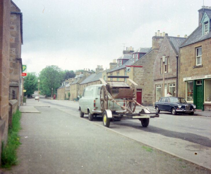 Van towing trailer carrying horse cart